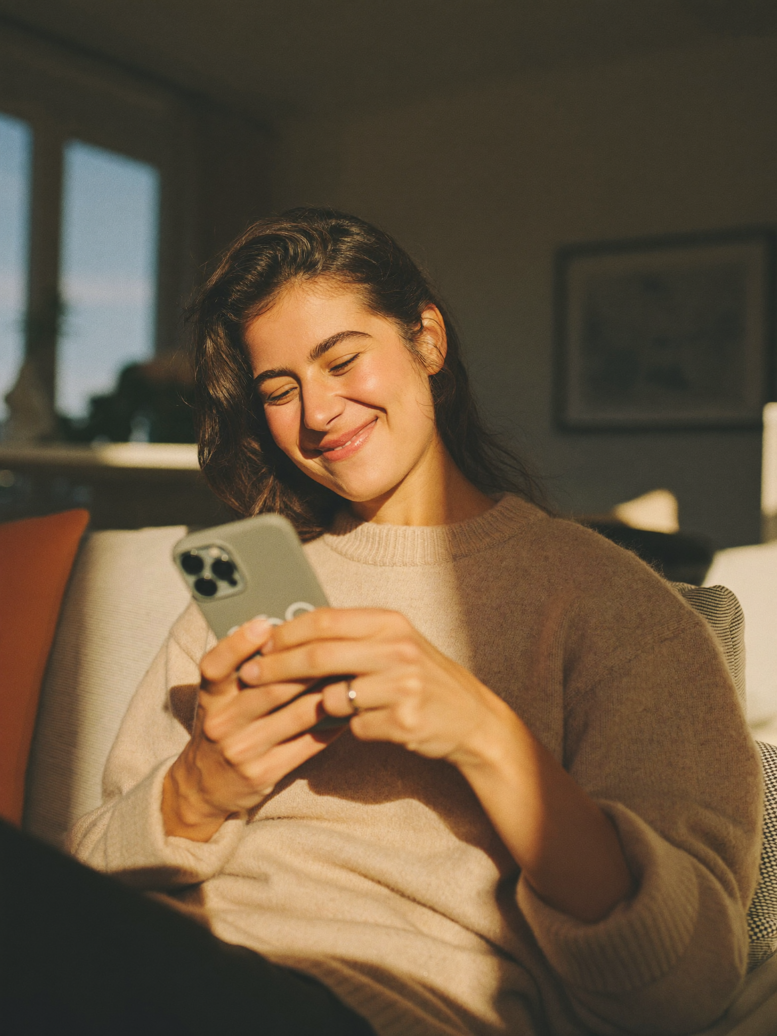 A relieved mother relaxed at home, at ease checking her phone