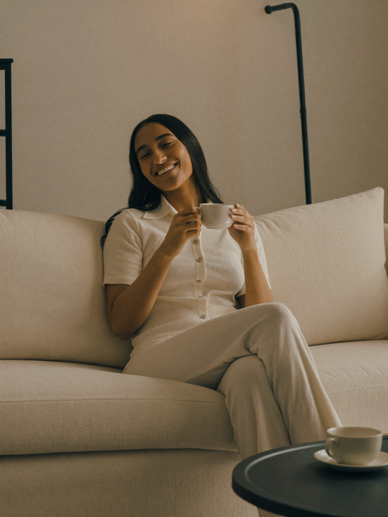 A relaxed mother at home, at ease with a cup of tea, no longer worried about money